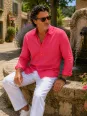 Homme portant une chemise en lin homme manches longues fuchsia Luberone assis sur une fontaine dans un village provençal