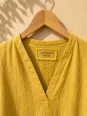 Close-up of the V-neck and linen label of the women's long yellow Rustrel dress