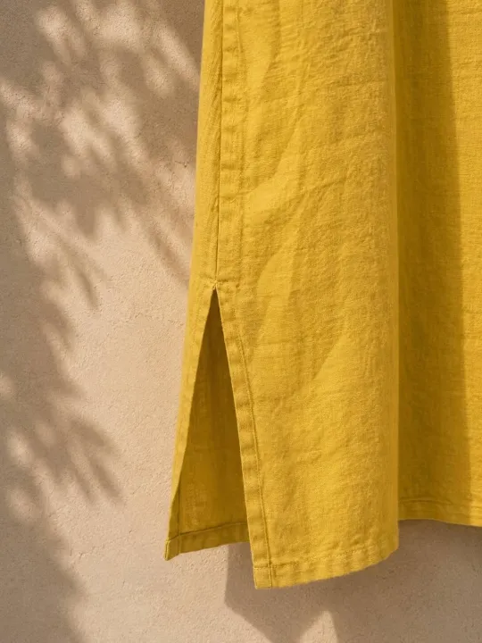 Détail de la fente latérale de la robe longue en lin jaune Rustrel