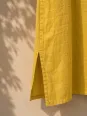 Détail de la fente latérale de la robe longue en lin jaune Rustrel