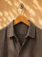 Close-up of the shirt collar and label on the taupe linen Ménerbes dress