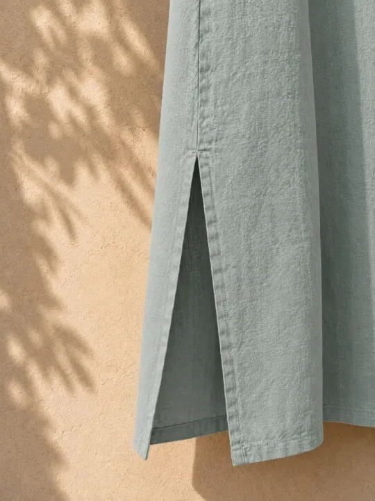 Close-up of the side slit of the women's sage green long linen dress Rustrel