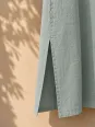 Close-up of the side slit of the women's sage green long linen dress Rustrel