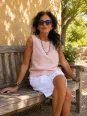 Women's salmon linen sleeveless top Lauris worn on a wooden bench in the Luberon
