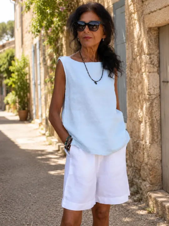 Femme portant le top en lin bleu ciel sans manches Lauris dans une rue du Luberon