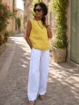 Femme portant le top en lin jaune sans manches Lauris dans une ruelle du Luberon