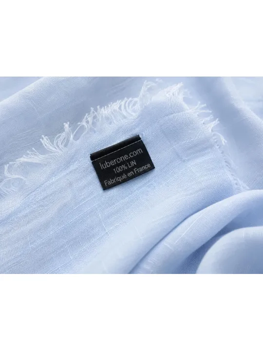 Détail du tissu en lin bleu ciel et des franges de l'écharpe