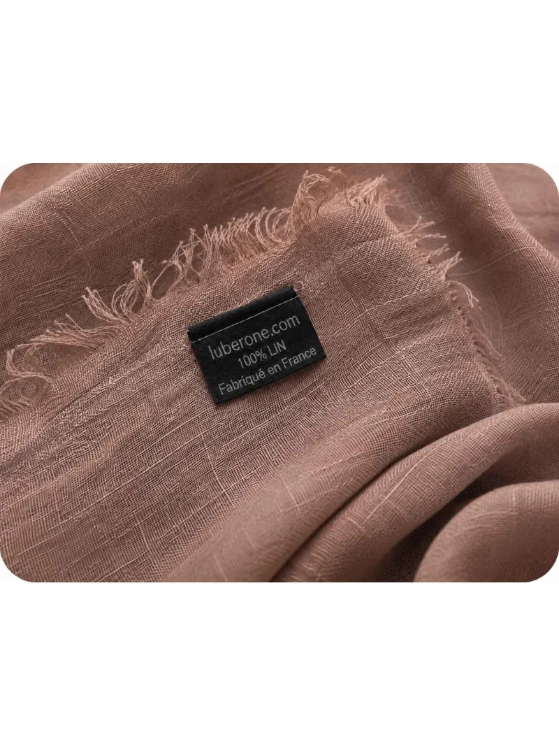 Détail du tissu en lin marron et des franges de l'écharpe