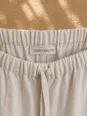 Elastic waistband and label detail of women's sand linen trousers
