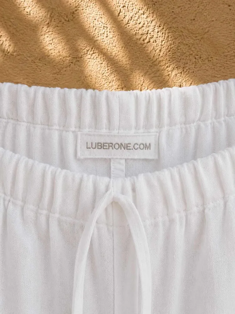 Étiquette LUBERONE.COM et taille élastique du pantalon en lin blanc femme