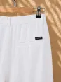 Back pocket detail of women's white pleated linen trousers