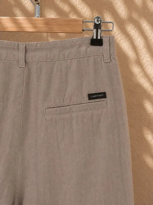 Rear pocket detail of women's beige pleated linen trousers