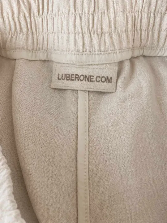 Inside view of women's sand linen Bermuda shorts showing the linen fabric and brand label.