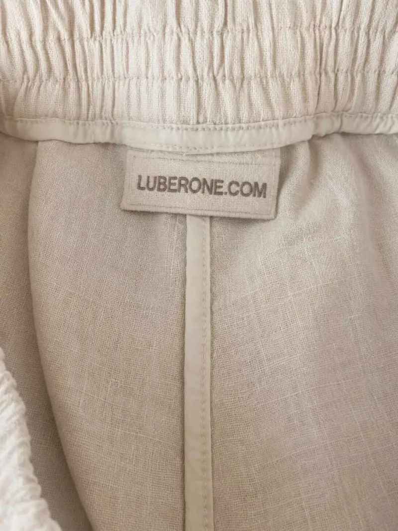 Inside view of women's sand linen Bermuda shorts showing the linen fabric and brand label.