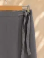 Close-up of the fastening on the women's taupe linen wrap skirt