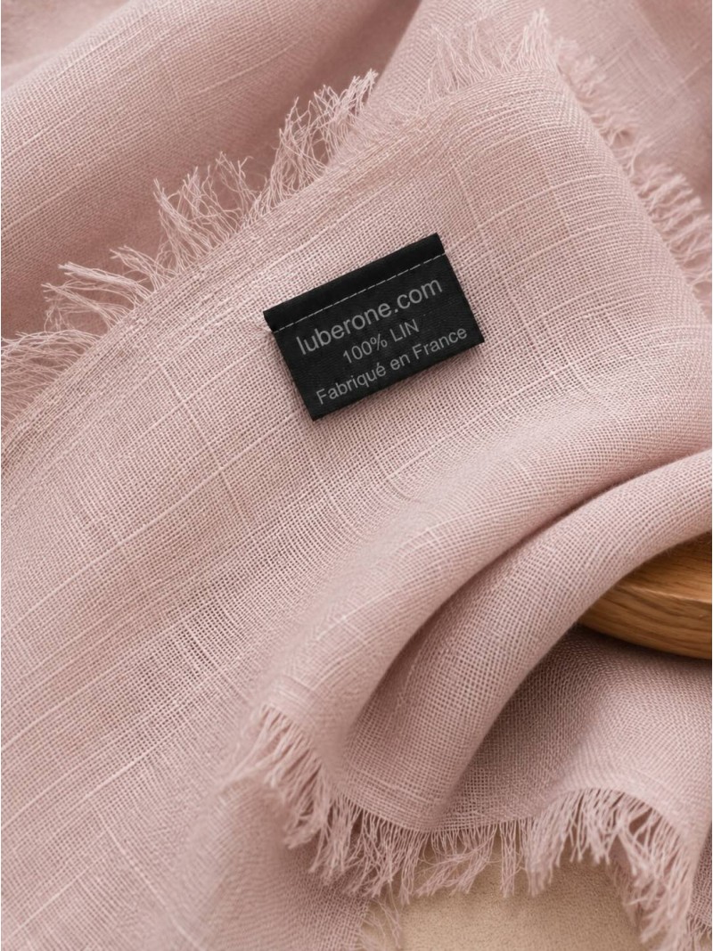 Détail du tissu en lin rose et des franges de l'écharpe